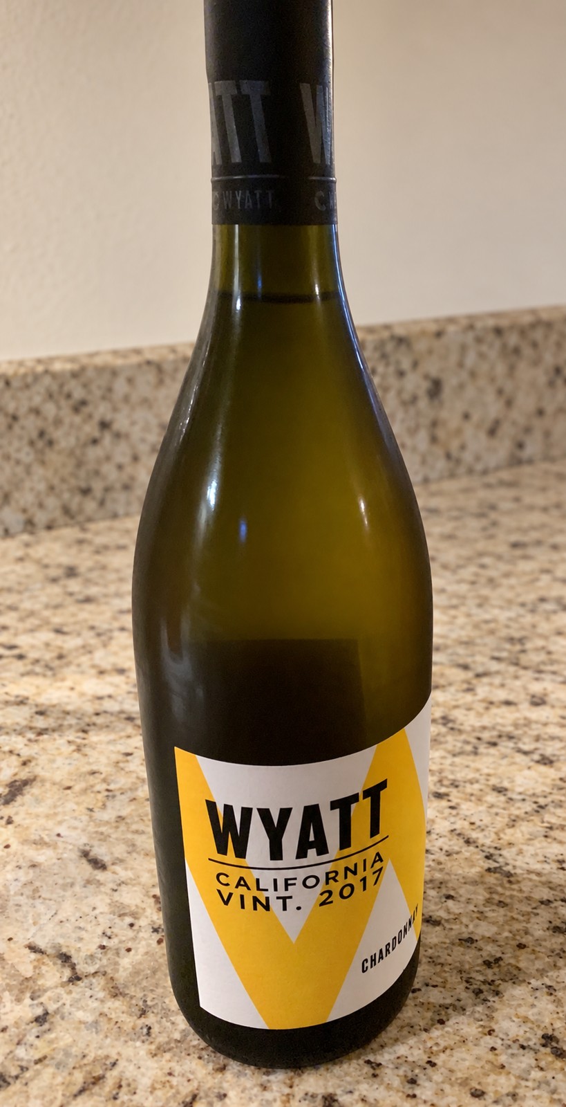 A bottle of Wyatt California Chardonnay standing on a kitchen counter.