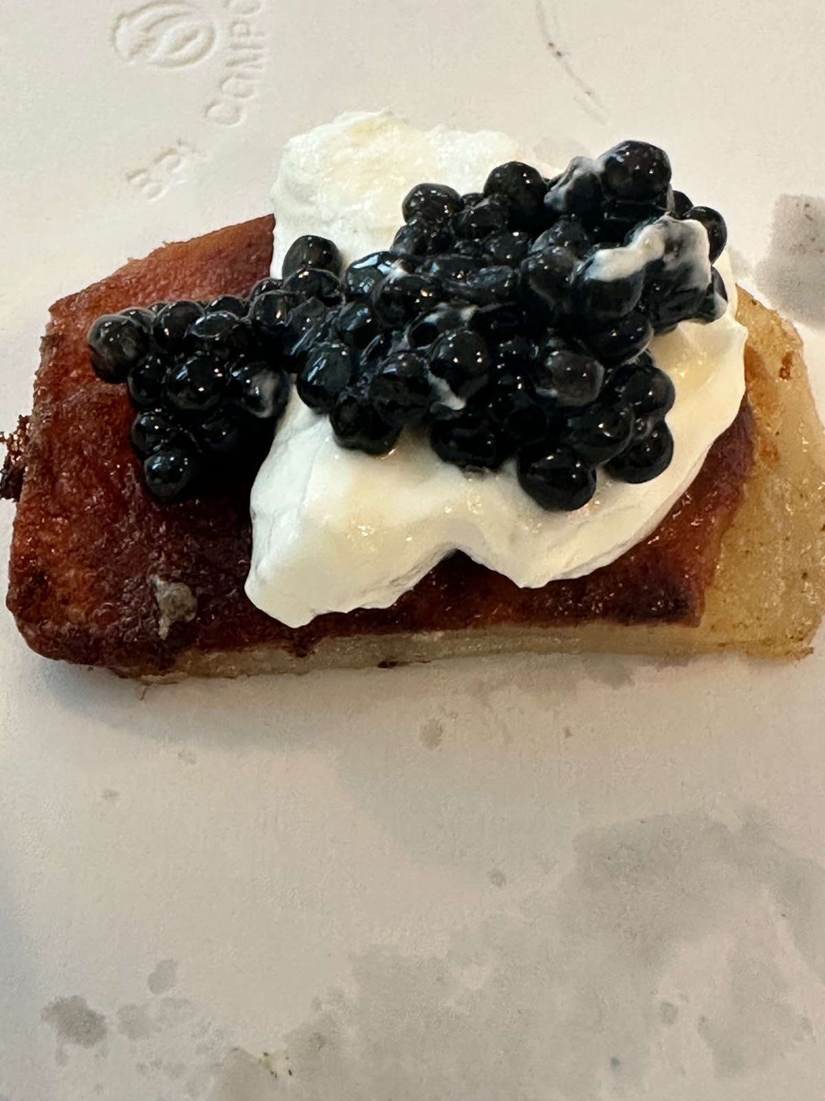 A slice of golden cake topped with whipped cream and glossy blueberries